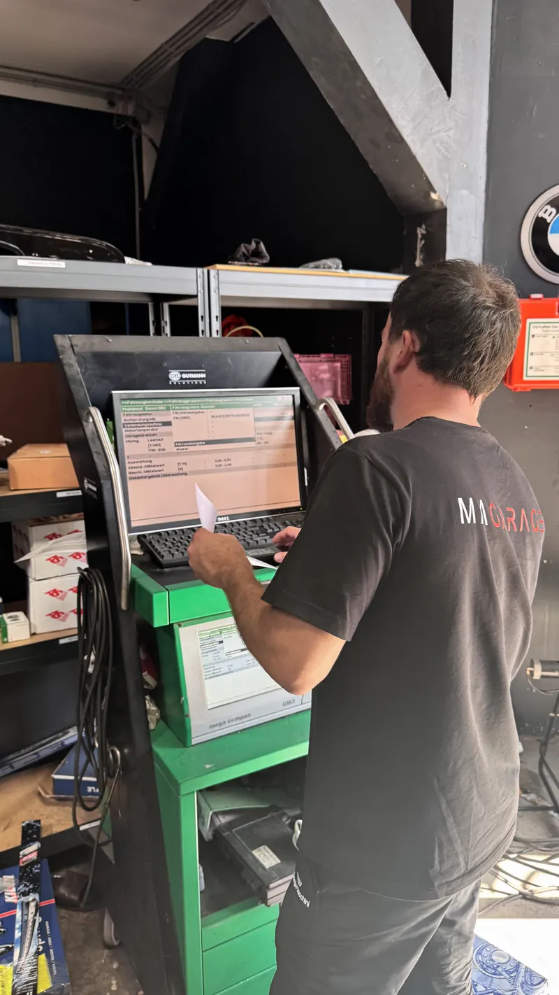 Fehlerdiagnose in der Magarage: Mechaniker liest den Fehlerspeicher am Diagnosegerät aus