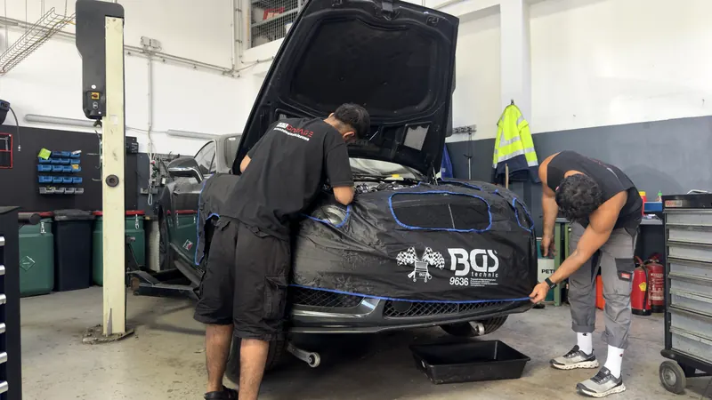 Abgedeckte Frontpartie eines Fahrzeugs während der Reparatur in der Magarage
