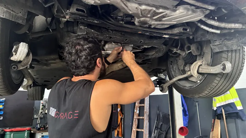 Montagearbeit am Unterboden eines Pkw in der Werkstatt der Magarage