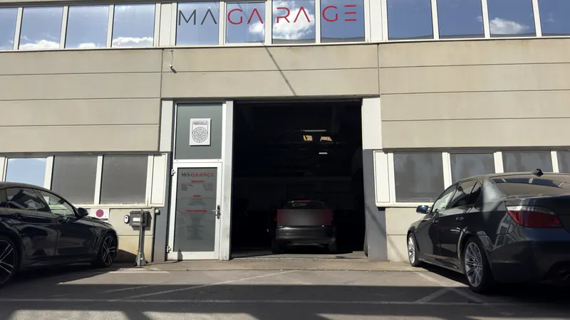 Außenansicht der freien Kfz-Werkstatt Magarage in Wien Liesing mit Firmenschild über der Halle