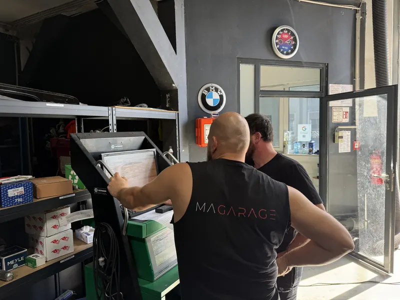 Zwei Mitarbeiter der Magarage am Diagnosegerät in der Werkstatt in 1230 Wien