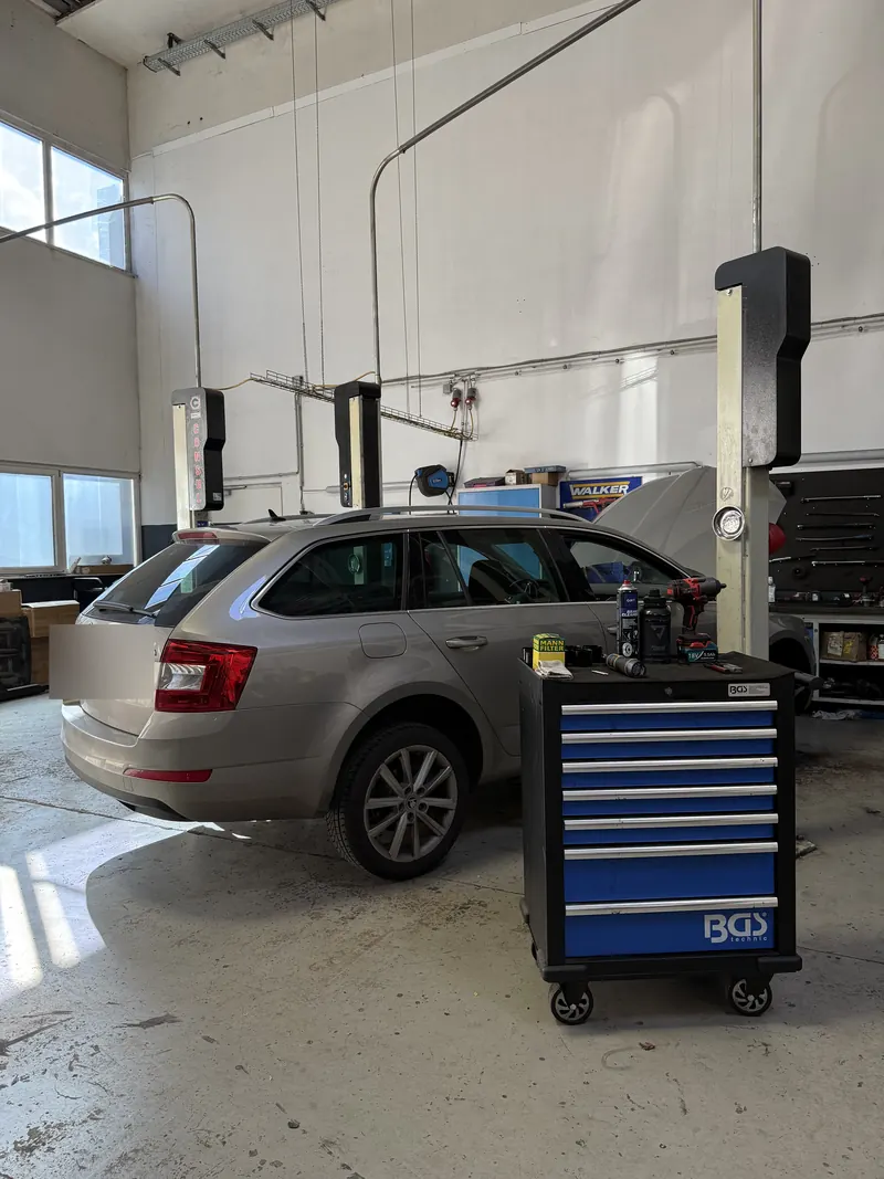 Kombi auf der Hebebühne in der Werkstatthalle der Magarage, daneben ein Werkzeugwagen